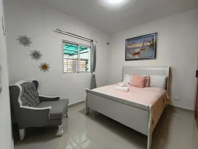 a bedroom with a bed and a chair and a window at América Colares VII in Los Frailes