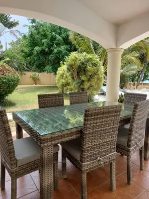 a dining room table and chairs on a porch at Villa can canet in Nizao