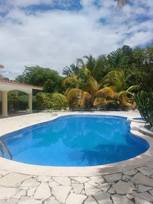 a large blue swimming pool next to a resort at Villa can canet in Nizao