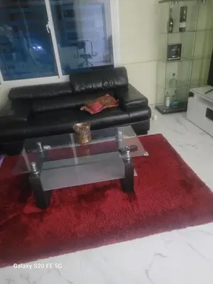 a living room with a red rug and a black couch at Bienvenido a casa in San Pedro de Macorís