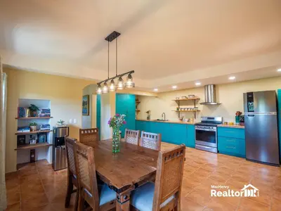 a kitchen with a wooden table and blue cabinets at Casa Estrella, Where Relaxation Begins in Sosúa