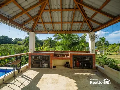 an outdoor patio with a fireplace and a table at Casa Estrella, Where Relaxation Begins in Sosúa