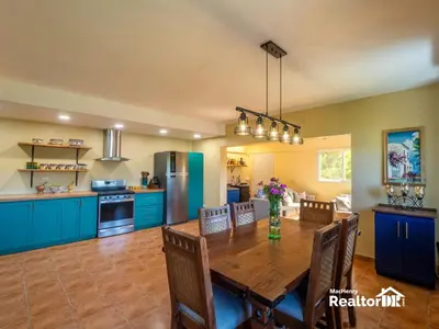 a large kitchen with a wooden table and blue cabinets at Casa Estrella, Where Relaxation Begins in Sosúa