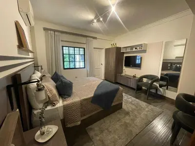 a bedroom with a bed and a living room at Estancia Azul by Fusion Market in Santo Domingo