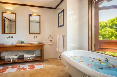 a bathroom with a tub and two sinks and a window at Villa Maji Luxury Private Villa Steps from the Ocean Sea Horse Ranch Cabarete in Cabarete