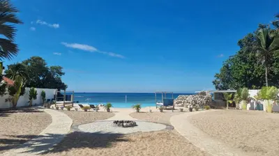 a beach with a fire pit and the ocean at Villas Caribe in Juan Dolio