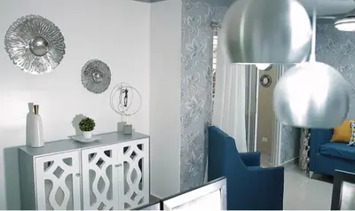 a living room with a blue chair and a table at Residencial Mediterraneo III in Santiago de los Caballeros