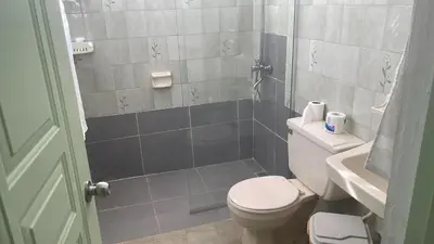 a small bathroom with a toilet and a shower at FredyGreenHouse in Santiago de los Caballeros
