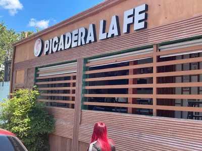 a woman walking in front of a pizza garage at FredyGreenHouse in Santiago de los Caballeros