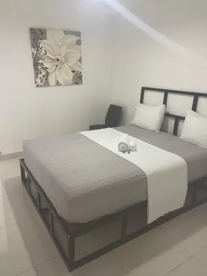 a bedroom with a large bed with white sheets at Plata View Center Habitacion 2D in Monte Plata