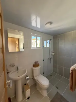 a bathroom with a toilet and a sink and a shower at spectrum stay in Baní