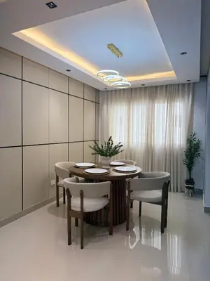 a dining room with a table and chairs and a ceiling at spectrum stay in Baní