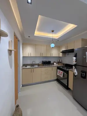 a kitchen with wooden cabinets and a refrigerator at spectrum stay in Baní