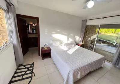 a bedroom with a white bed and a window at Two residences for one stay in Sosua in Sosúa