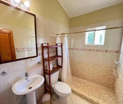 a bathroom with a sink and a toilet and a mirror at Two residences for one stay in Sosua in Sosúa