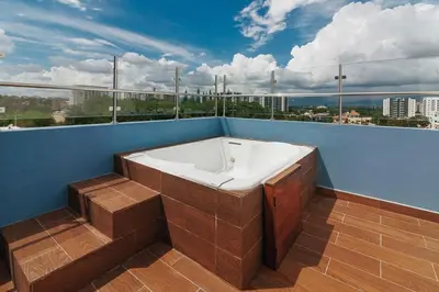 a bath tub sitting on the side of a balcony at Exclusive Top-Floor Penthouse with Jacuzzi - BlueCasas in Santiago de los Caballeros