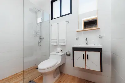 a white bathroom with a toilet and a sink at Exclusive Top-Floor Penthouse with Jacuzzi - BlueCasas in Santiago de los Caballeros