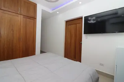 a bedroom with a bed and a flat screen tv at Exclusive Top-Floor Penthouse with Jacuzzi - BlueCasas in Santiago de los Caballeros