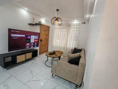 a living room with a tv and a chair and a table at Condominio Esperanza B102 in San Pedro de Macorís