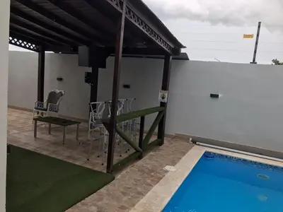 a patio with a pool and chairs and a table at Naime 3 Bristol villa in San Pedro de Macorís