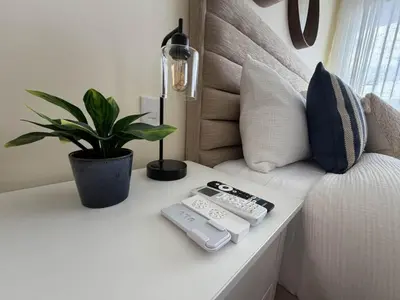 a table with two remote controls and a potted plant at Modern 1B 5 min to CapCana Beach in Las Terrenas
