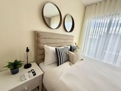 a bedroom with a bed with a mirror and a window at Modern 1B 5 min to CapCana Beach in Las Terrenas