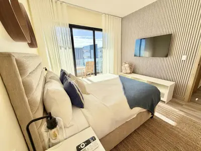 a bedroom with a large bed and a television at Modern 1B 5 min to CapCana Beach in Las Terrenas