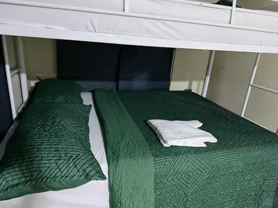 a bed with green comforter and pillows on a boat at Hermosa Villa en Cabrera vista al Mar y montañas in Cabrera