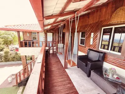 a porch of a house with a black couch on it at Hermosa Villa en Cabrera vista al Mar y montañas in Cabrera