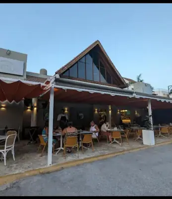 a group of people sitting at tables outside of a building at Your Beautiful Village Central 5 Min from the Beach in Punta Cana