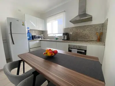 a kitchen with a wooden table with a bowl of fruit on it at Your Beautiful Village Central 5 Min from the Beach in Punta Cana