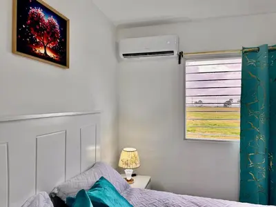 a bedroom with a bed and a window at Ocean View Fast Wifi Close to Everything Coffee 2BR in La Cana