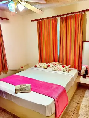 a bedroom with a bed with a pink blanket on it at Casa mar in Las Galeras