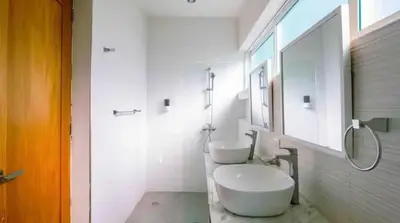 a white bathroom with two sinks and a mirror at Ocean reset in Sosúa