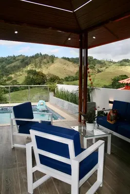 a patio with blue and white chairs and a pool at Villa lobos in Concepción de La Vega