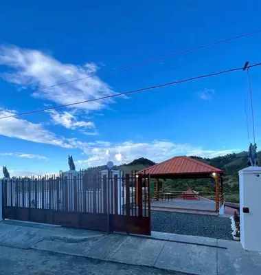 a fence with a gazebo and a blue sky at Villa lobos in Concepción de La Vega