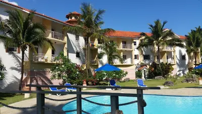 a view of a resort with a pool and palm trees at Cozy Garden Oasis Steps to the Beach in Cabarete