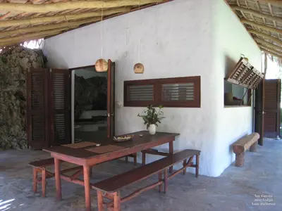 a wooden table and bench in front of a room at La Cueva Eco-Lodge in Las Galeras