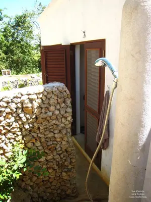 a shower with a hose next to a stone wall at La Cueva Eco-Lodge in Las Galeras