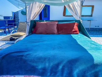 a blue bed with two red pillows on it at Sunset Samana in Las Galeras