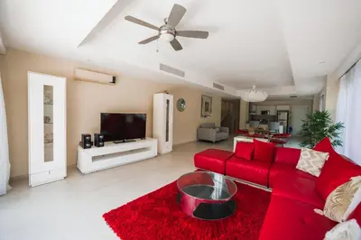 a living room with a red couch and a tv at Luxury Private Villas with Pool, Private Beach, BBQ in Punta Cana