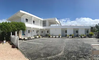 a large white building with a parking lot at Albergo El Pulpo, Bayahíbe in Bayahibe