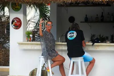 two women standing on stools in a bar at Nuovo Hotel Playa Catalina in La Romana