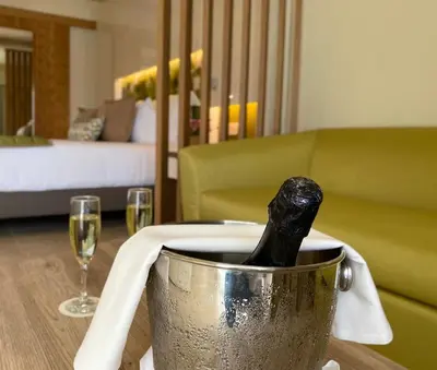a champagne bottle in a bucket on a table with wine glasses at Dreams Onyx Resort & Spa - All Inclusive in Punta Cana