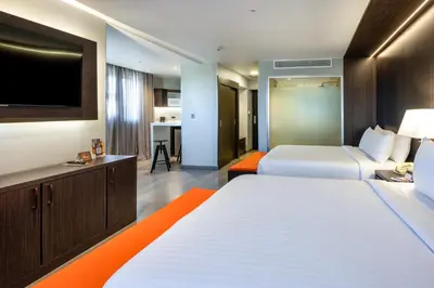 a hotel room with two beds and a flat screen tv at W&P Santo Domingo in Santo Domingo