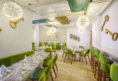 a dining room with tables and green chairs at Viva Tangerine by Wyndham, A Trademark All Inclusive in Cabarete