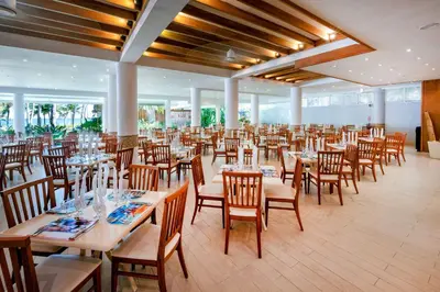 a dining room with tables and chairs in it at Viva Tangerine by Wyndham, A Trademark All Inclusive in Cabarete
