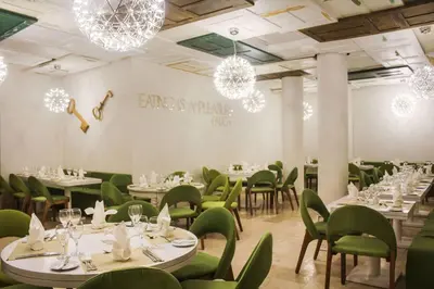 a dining room with tables and chairs and chandeliers at Viva Tangerine by Wyndham, A Trademark All Inclusive in Cabarete