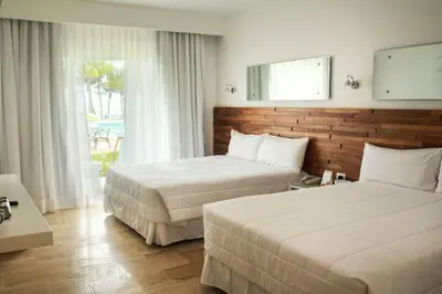 a hotel room with two beds and a window at Viva Tangerine by Wyndham, A Trademark All Inclusive in Cabarete