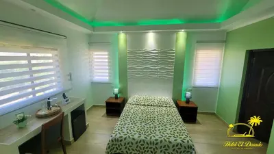 a bedroom with a bed in a room with green lights at Hotel El Dorado in La Romana